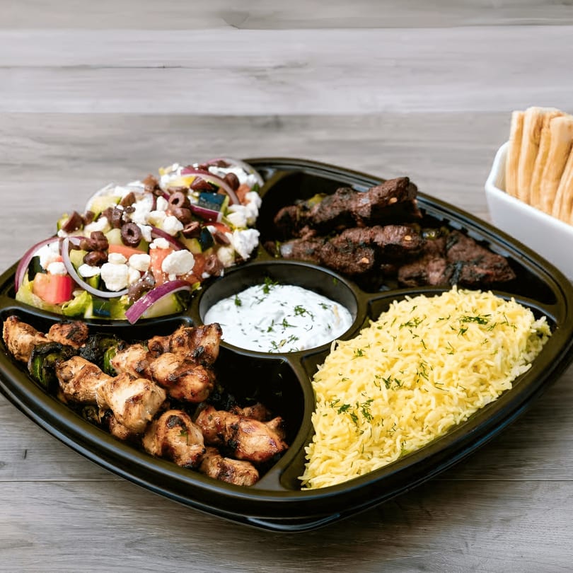 Daphne's Greek Cafe's platter with chicken and beef skewers, rice, Greek salad, and tzatziki.