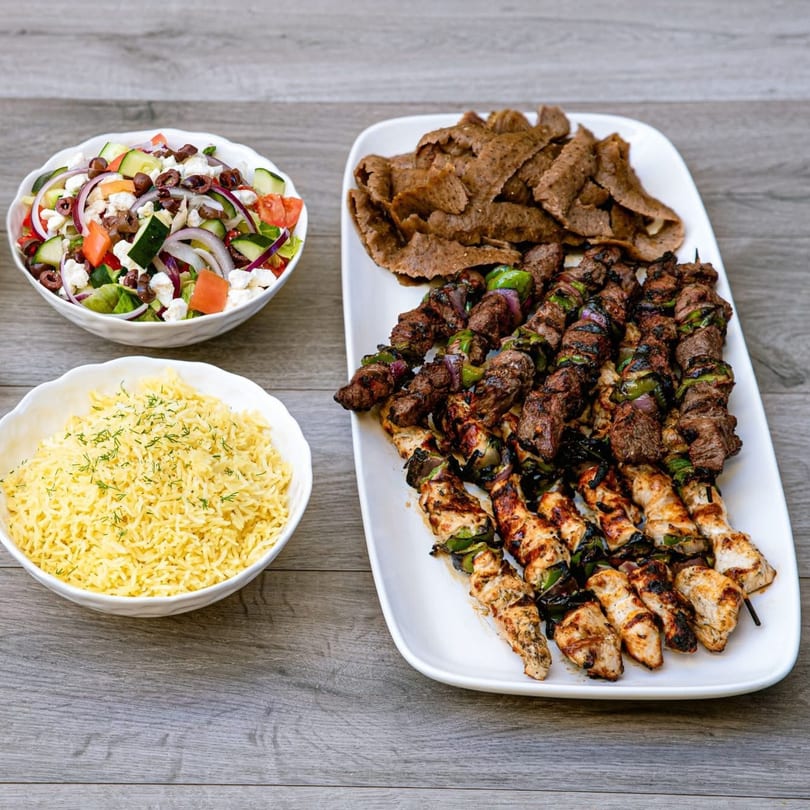 A Daphne's Greek Cafe platter with gyro meat, chicken and beef skewers, rice, and Greek salad.