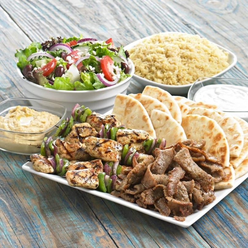 Daphne's Greek Cafe platter with chicken skewers, gyro meat, pita, hummus, rice, and Greek salad.
